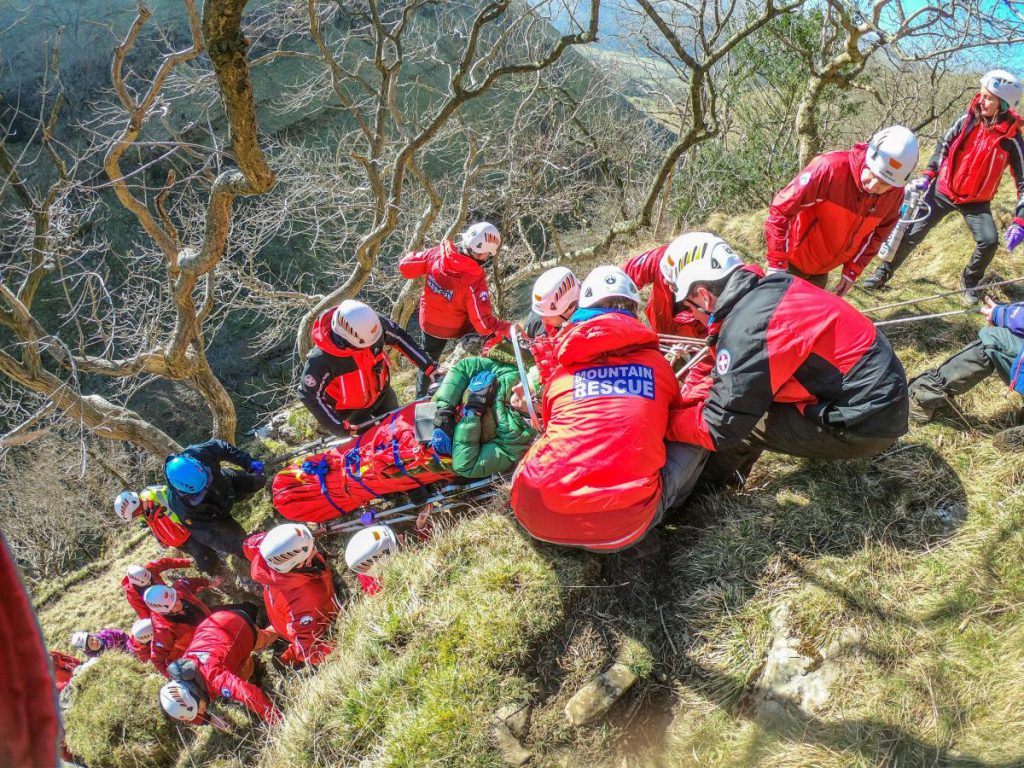 rescue team carry injured person in mountain